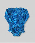 Blue floral-patterned baby romper on a wooden surface