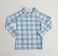 A long-sleeve children's rash guard or swim shirt with a light blue and white gingham check pattern, laid flat on a white textured fabric background.