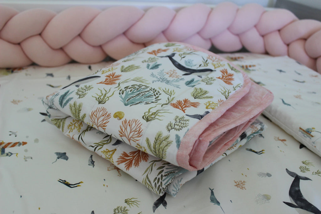 Folded fabric with nature-themed design on a matching pink background