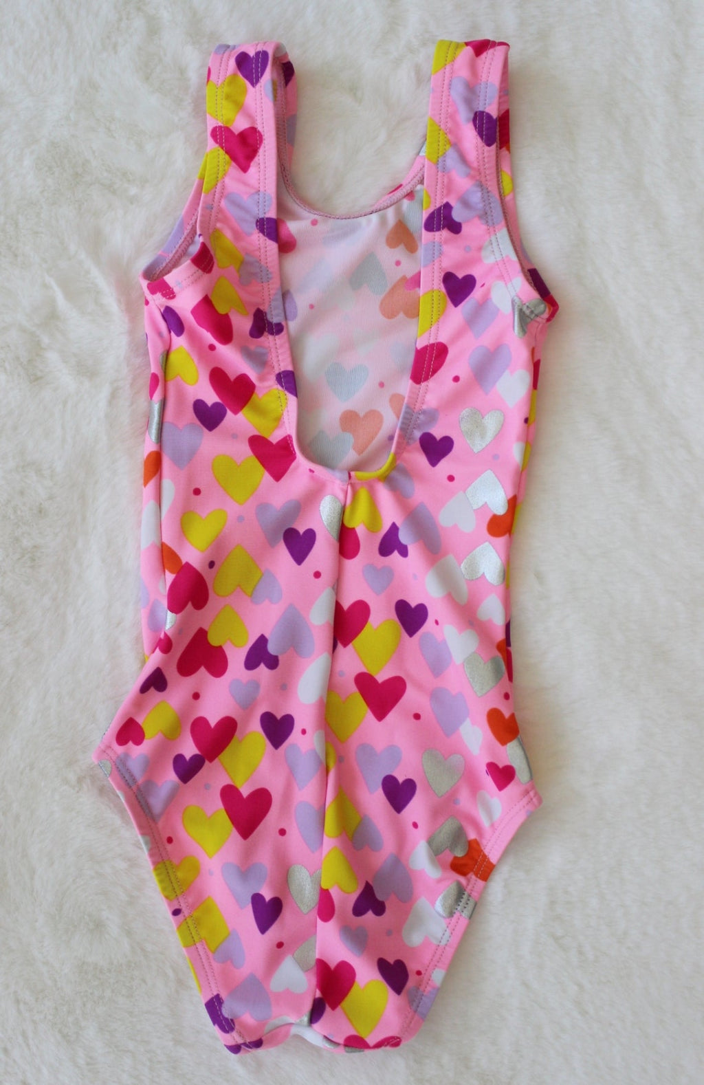 Pink swimsuit with colorful heart pattern on a white background