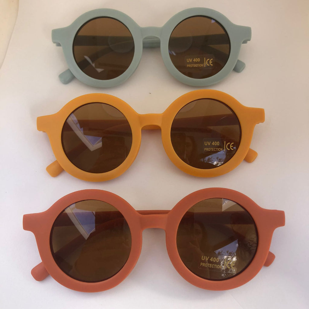 Three pairs of sunglasses with different colored frames on a white background