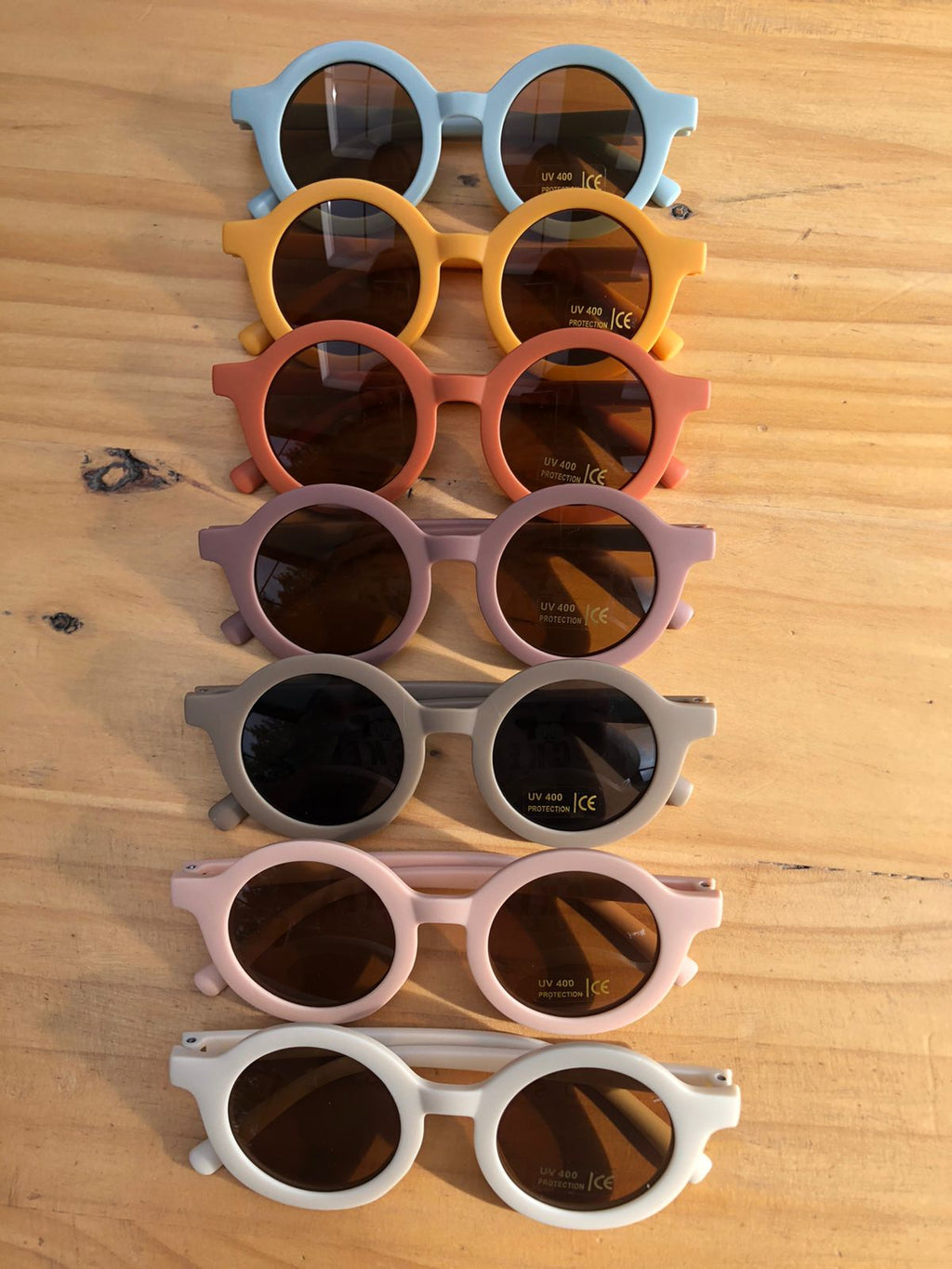 Collection of colorful sunglasses on a wooden surface