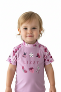 Pink children's shirt with floral sleeves and 'Lizzy' printed on it against a white background
