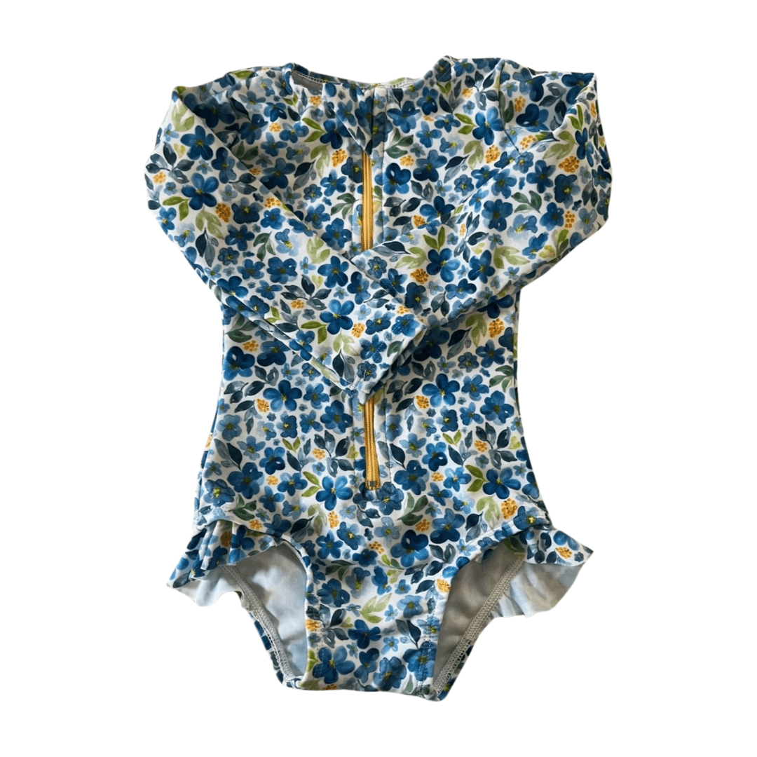 Floral-patterned baby swimsuit with a zipper on a white background from The Jake and Isla Collection