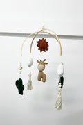 Baby mobile with hanging toys and decorations on a plain background