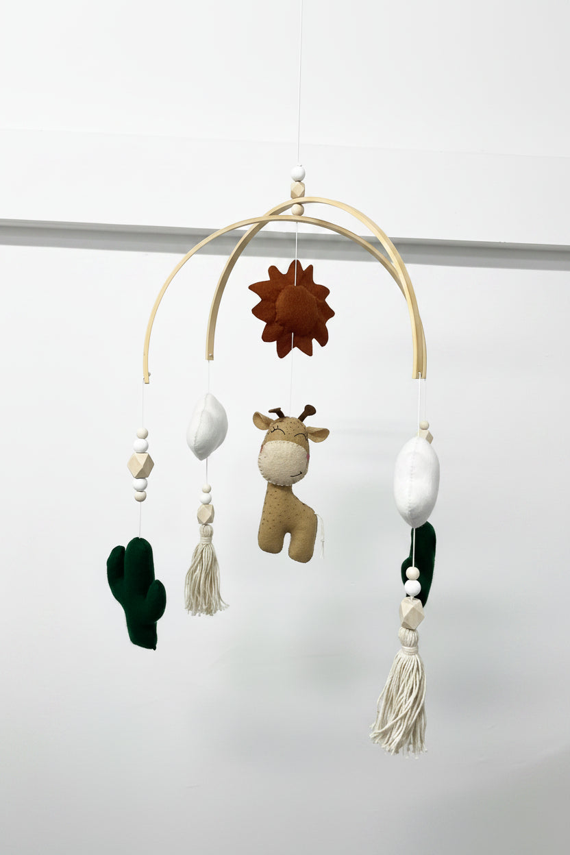 Baby mobile with hanging toys and decorations on a plain background
