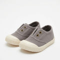 A pair of toddler canvas sneakers in a muted gray color with cream-colored soles and gold eyelets, shown on a white background. The image is captured within a mobile app screenshot, featuring a dark gray status bar at the top and bottom with the text 'Something went wrong'.