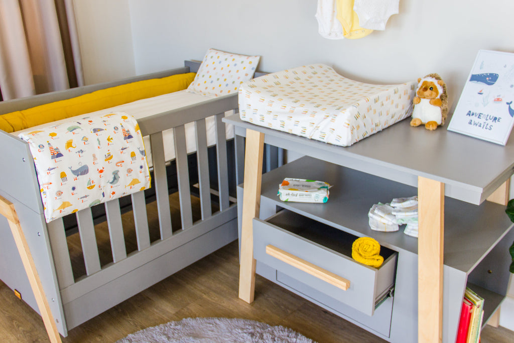 Nursery room with a crib, changing table, and baby items.
