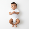 baby in white short sleeve envelope neck onsie on white background