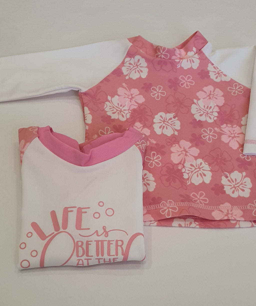 two long sleeve girls rashvest with hawaiian flower prints and wording from jake and isla swimwear 