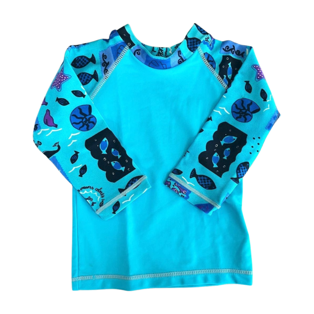 Children's blue rash guard with black and purple fish pattern on a white background