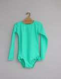 Green baby swimwear on a hanger against a gray background