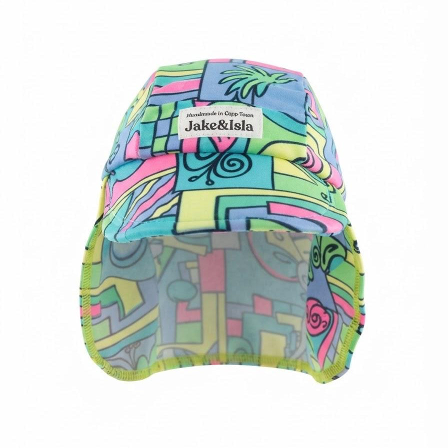 A swim hat with a vibrant multicolor abstract pattern in shades of blue, green, pink, and yellow. It features a white brand label on the front reading 'Jake&Isla Handmade in cape town'.