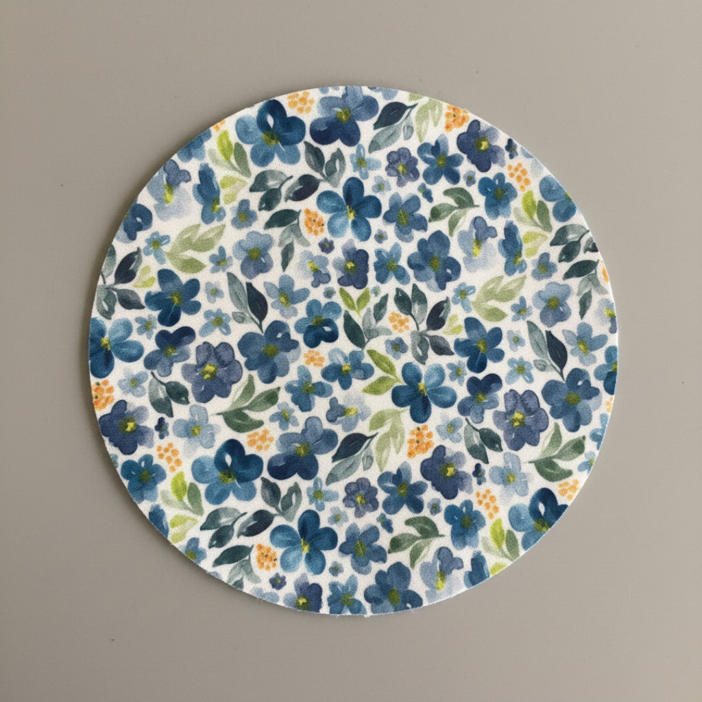 Patterned fabric with blue flowers and green leaves on a light background