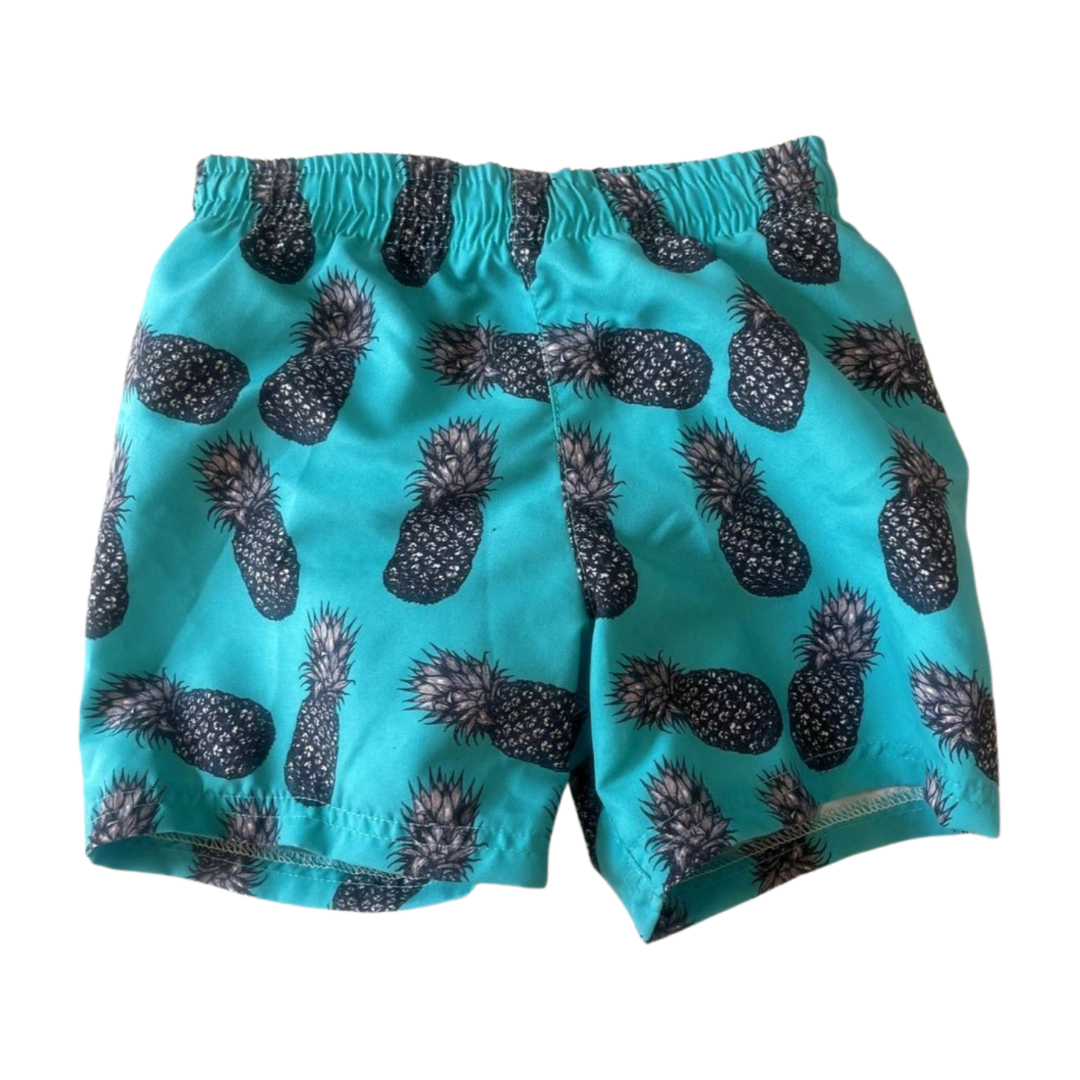 Turquoise swim shorts with built in swim nappy with black pineapple pattern on a white background