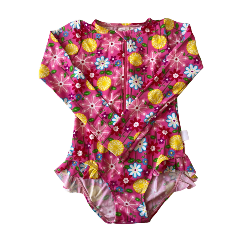 Pink floral and pineapple patterned baby swimsuit on a white background