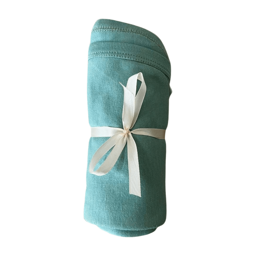 Teal fabric roll with a white ribbon on a white background