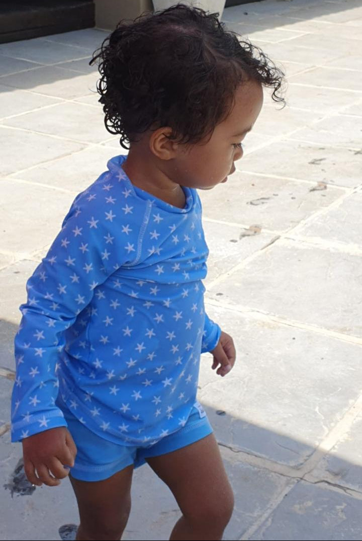 Little toddler wearing a rash vest and baby jammies from The Jake and Isla Collection