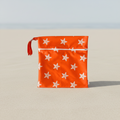 Orange pouch with white star patterns on a beach  background