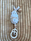 Baby pram dangle with llama design on a woven surface
