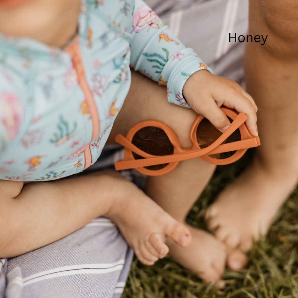 honey sunglasses in baby's hand